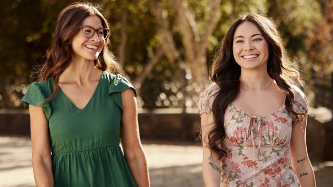 Dos mujeres caminando al aire libre y sonriendo